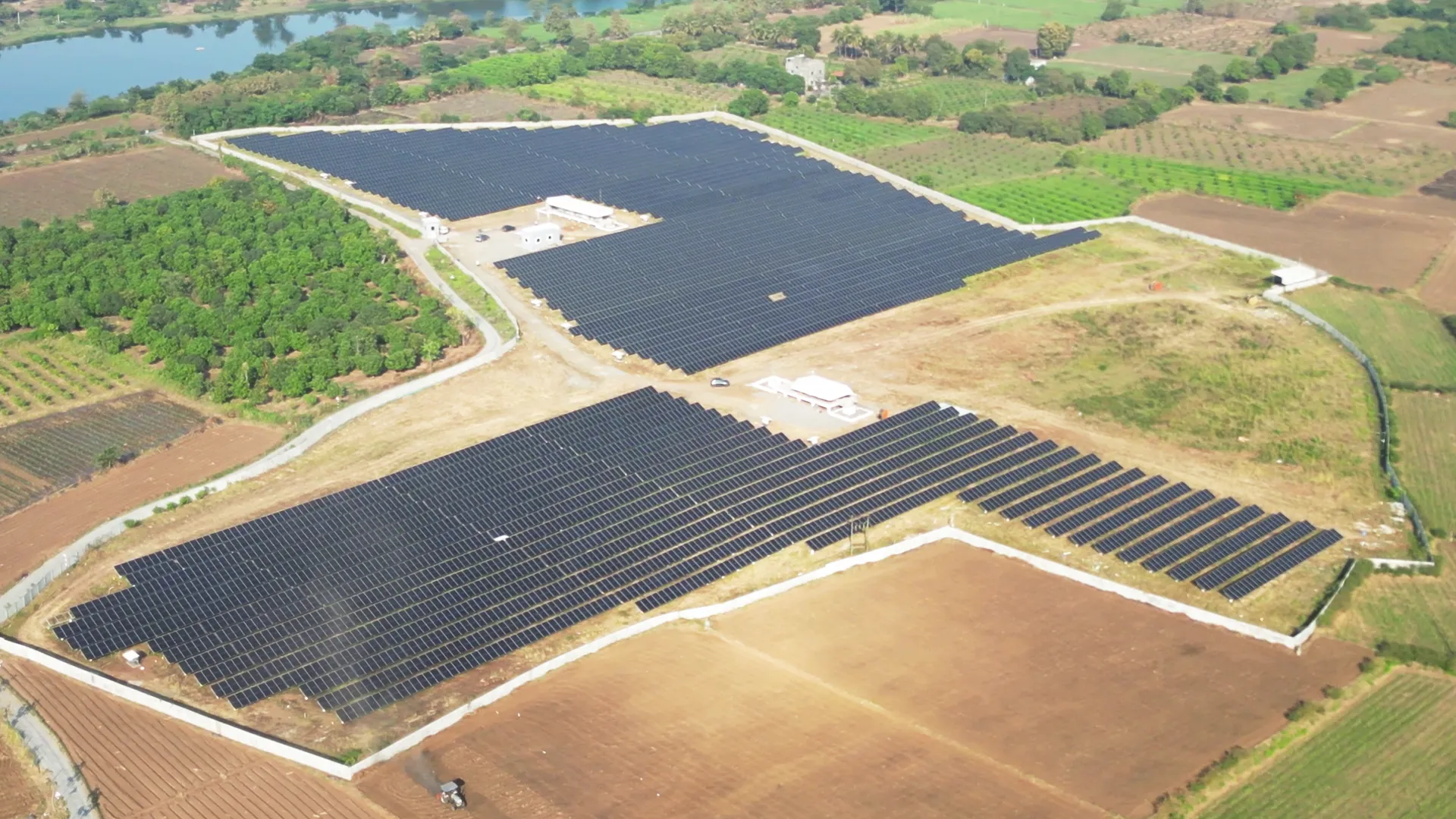 Ground-mounted solar panels at Rayzon Solar Park 6 in Goddha spread across open fields.