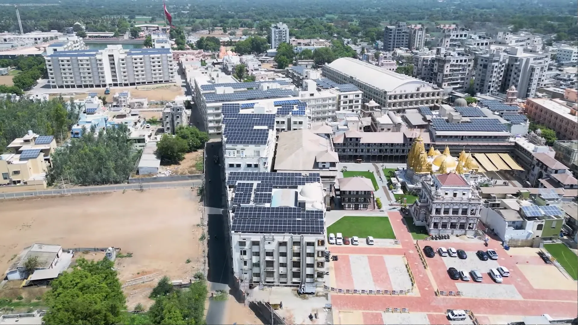 Extensive rooftop solar panel project at Ratnaveer Engineering Precision Ltd surrounded by farmland.