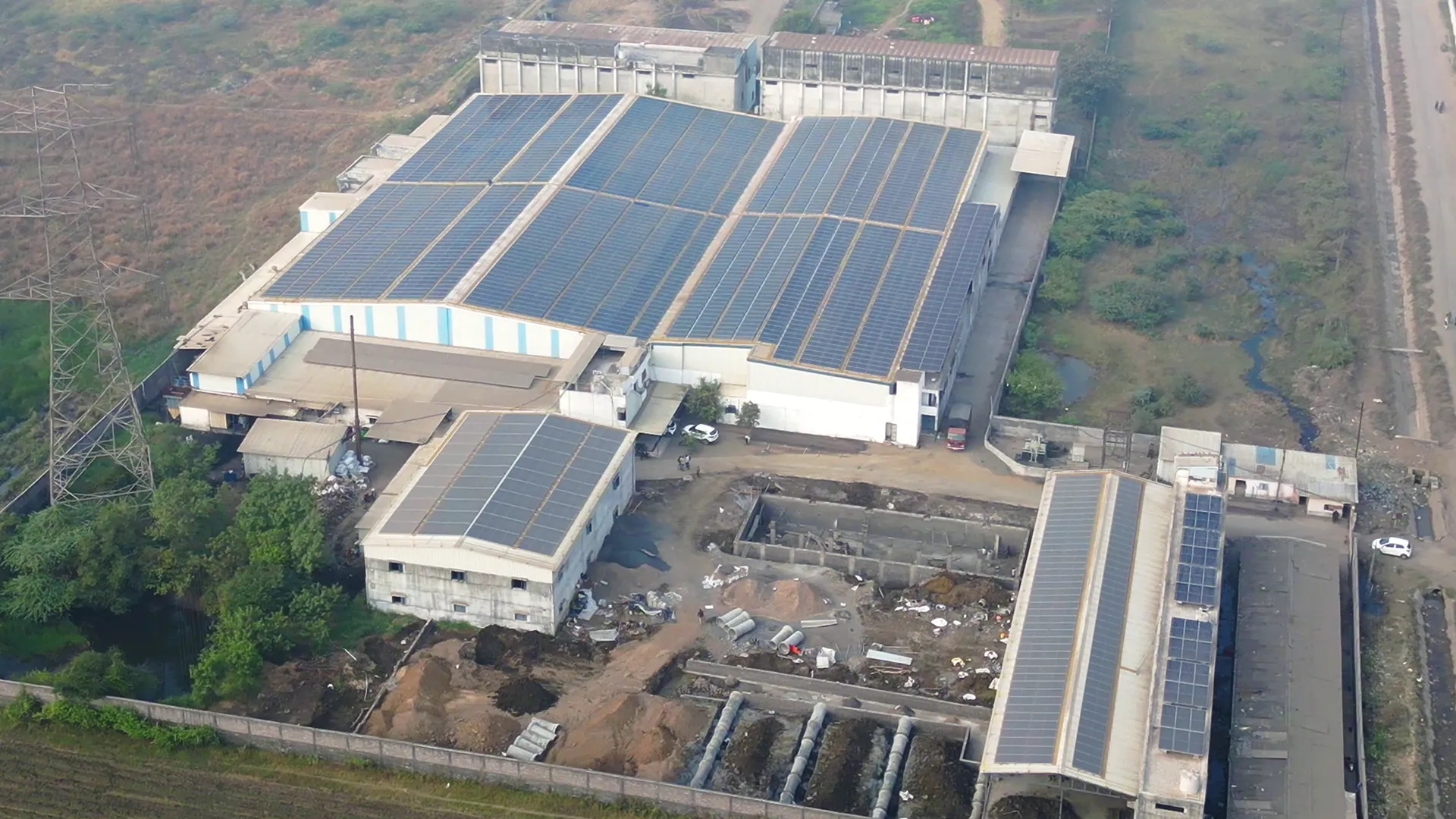 Aerial view of rooftop solar panels at Drishya Polyfills Pvt. Ltd industrial building.